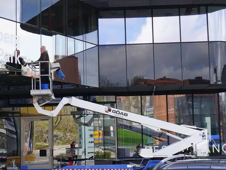 Fönsterputsare på en skylift putsar stora fönsterpartier på kontorsbyggnad i Göteborg