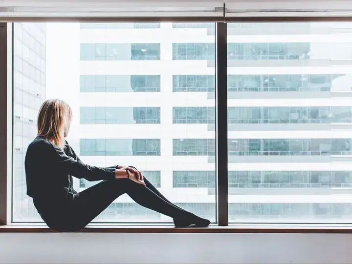 En kvinna sitter och tittar ut genom nyputsade fönster